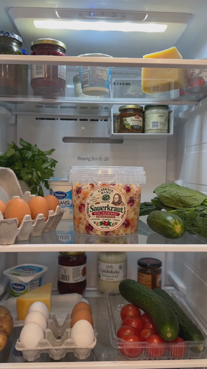 Cabbage Mama sauerkraut jar in an open fridge with fresh vegetables and eggs